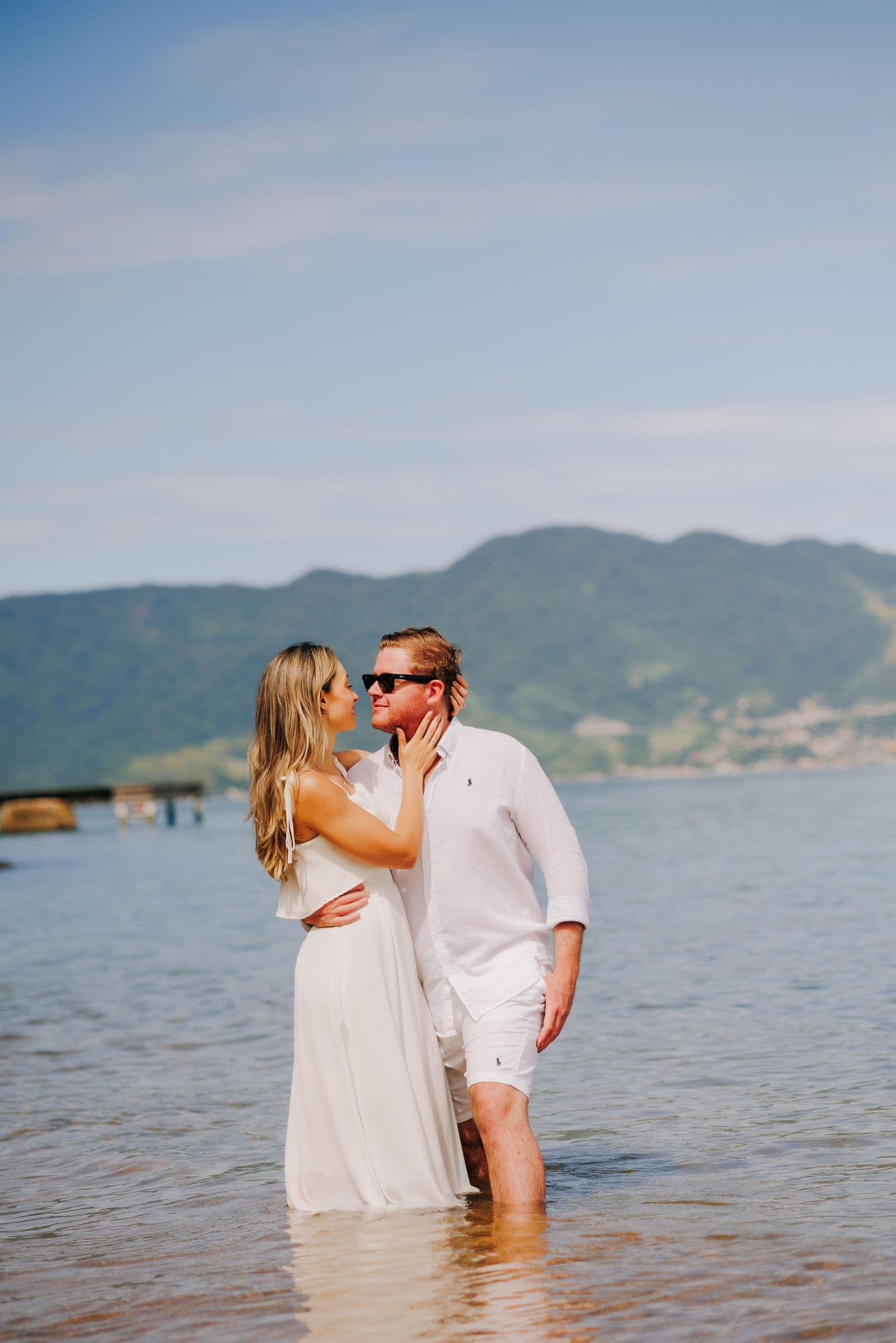 Bruna and Chris in the ocean with mountains behind